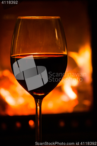 Image of Glass of red wine and fireplace