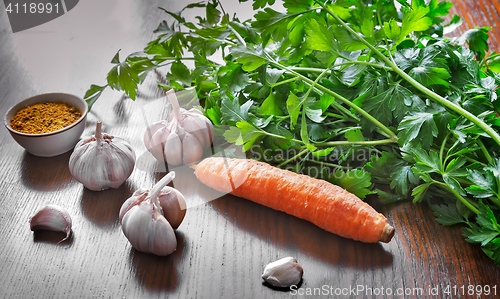 Image of Parsley leaves , carrots , garlic and spices.