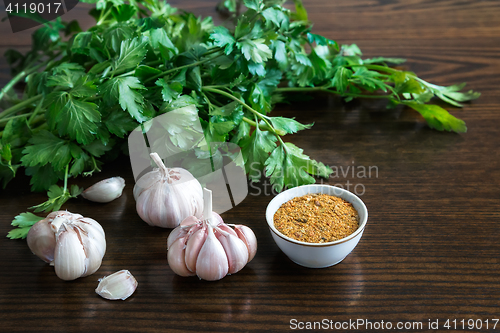 Image of Parsley leaves and garlic on the surface of the table.