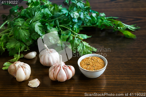 Image of Parsley leaves and garlic on the surface of the table.