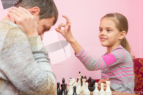 Image of My daughter has a finger on the pope\'s head, who lost a game of chess