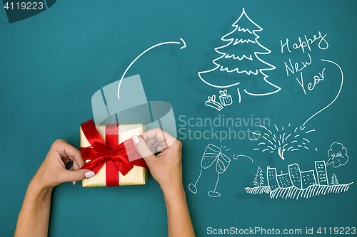 Image of Female hands holding gift on blue background