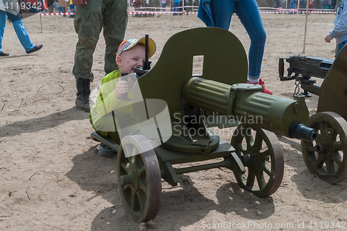 Image of The boy considers an old easel machine gun