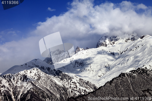 Image of Snow mountains in clouds in winter sun day