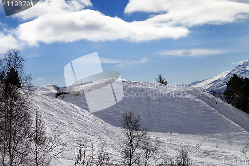 Image of Off-piste slope with traces from skis and snowboards in sun day