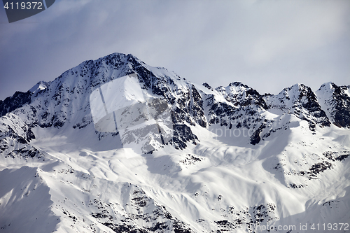 Image of Snow sunlight mountain and gray sky in evening