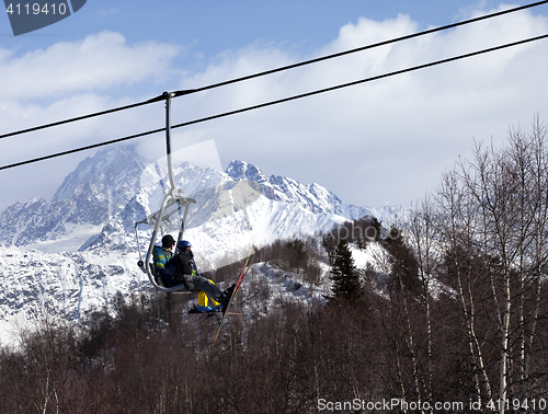 Image of Father and daughter on ski-lift at winter sun day