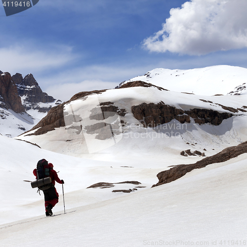 Image of Hiker in snow mountains at sun spring day