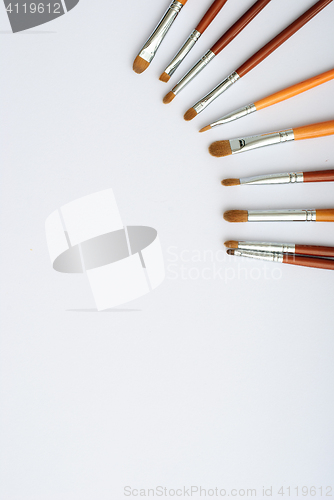 Image of makeup brush and cosmetics, on a white background