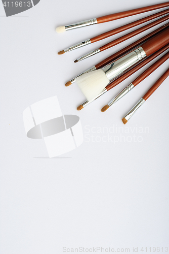 Image of makeup brush and cosmetics, on a white background