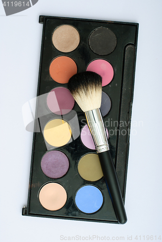 Image of makeup brush and cosmetics, on a white background