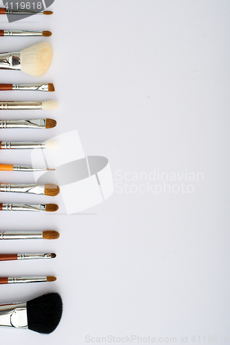 Image of makeup brush and cosmetics, on a white background