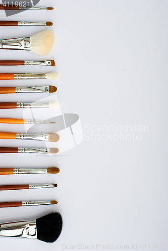 Image of makeup brush and cosmetics, on a white background