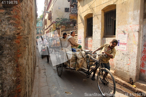 Image of Rickshaw-puller carrying goods on the road of Kolkata