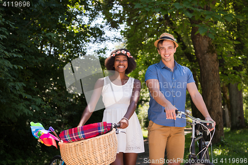 Image of Young  couple having joyful bike ride in nature