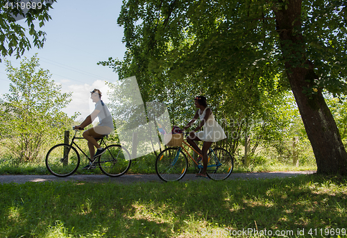 Image of Young  couple having joyful bike ride in nature