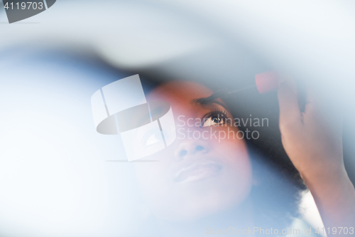 Image of woman making makeup while driving car