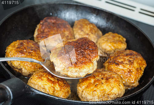 Image of Frying homemade meatballs in black iron pan, in fine broth