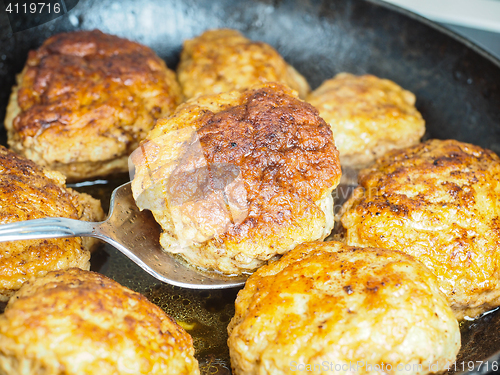 Image of Frying homemade meatballs in black iron pan, in fine broth