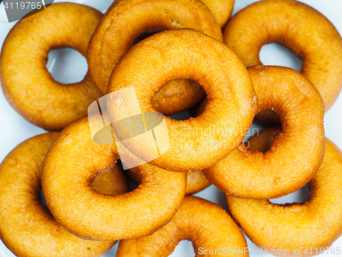 Image of Closeup of a plate with freshly made dark brown doughnuts 