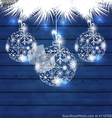 Image of Christmas balls made in snowflakes on blue wooden background