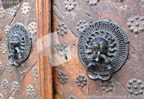 Image of Iron lion knockers on a wooden door
