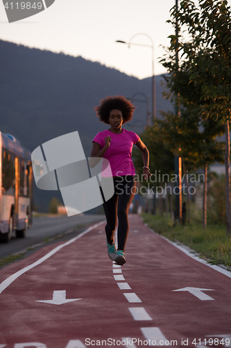 Image of a young African American woman jogging outdoors