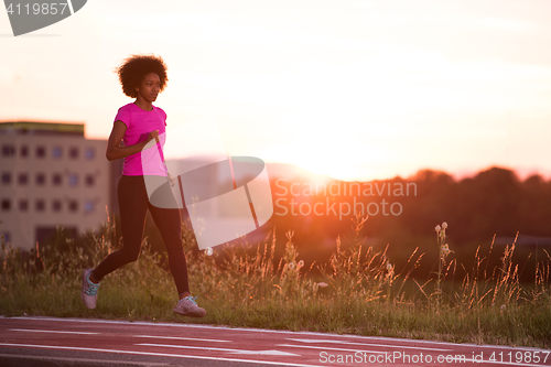 Image of a young African American woman jogging outdoors