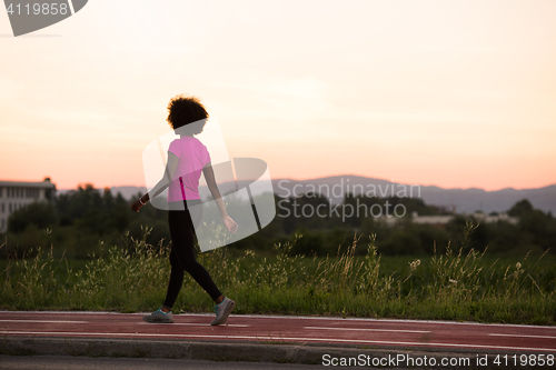 Image of a young African American woman jogging outdoors
