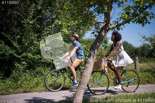 Image of Young  couple having joyful bike ride in nature