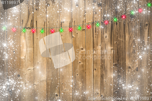 Image of Wooden Background with Christmas Lights and Snowy Border