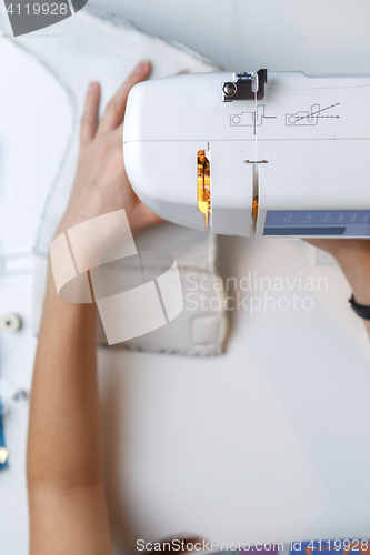 Image of Girl tailoring fabric on sewing-machine