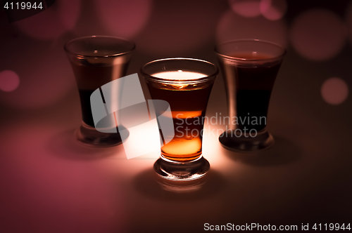 Image of red and tow shot glass on a dark background in the spot light