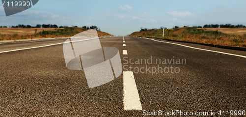 Image of asphalt road through the field 