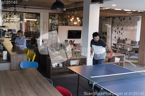 Image of playing ping pong tennis at creative office space