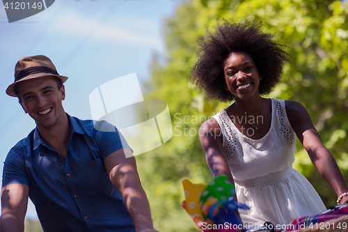 Image of Young  couple having joyful bike ride in nature