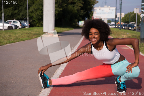 Image of Portrait of sporty young african american woman stretching outdo