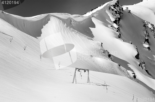 Image of Black and white view on old surface lift and mountains with snow