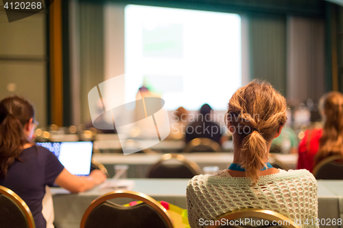 Image of Audience in lecture hall participating at business conference.