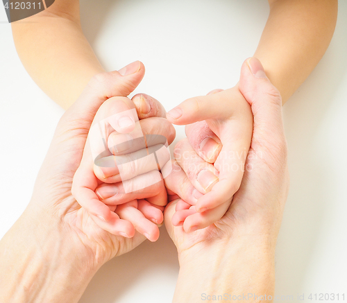 Image of Toddlers hands in fathers hands, towards, on a white table