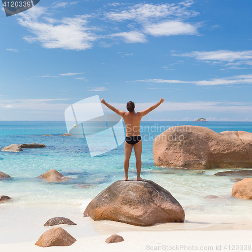 Image of Woman enjoying Anse Lazio picture perfect beach on Praslin Island, Seychelles.