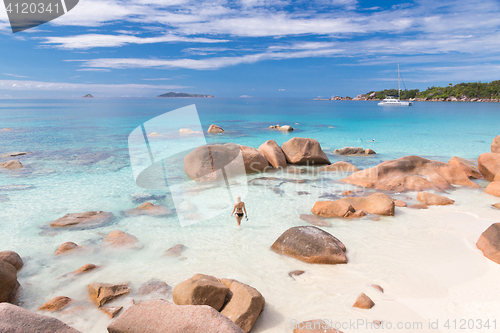 Image of Woman enjoying Anse Lazio picture perfect beach on Praslin Island, Seychelles.