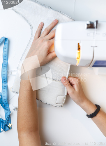 Image of Girl tailoring boot on sewing-machine