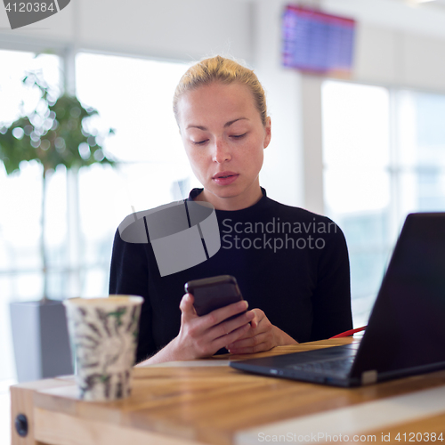 Image of Female freelancer remotely working on the go.