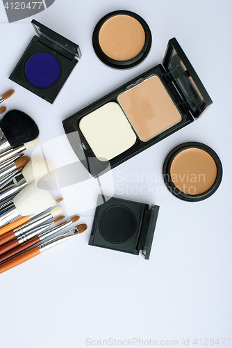 Image of makeup brush and cosmetics, on a white background