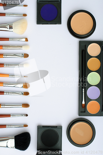 Image of makeup brush and cosmetics, on a white background