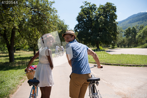 Image of Young  couple having joyful bike ride in nature