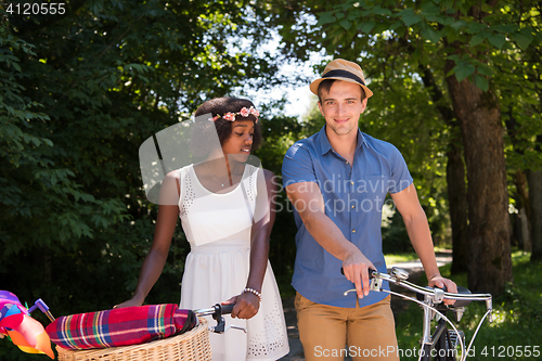 Image of Young  couple having joyful bike ride in nature