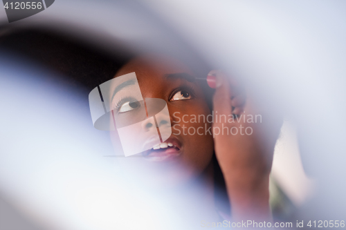 Image of a young African-American woman makeup in the car