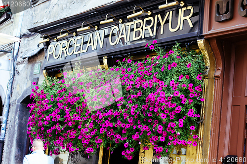 Image of Ljubljana, shop sign decorated with red flowers